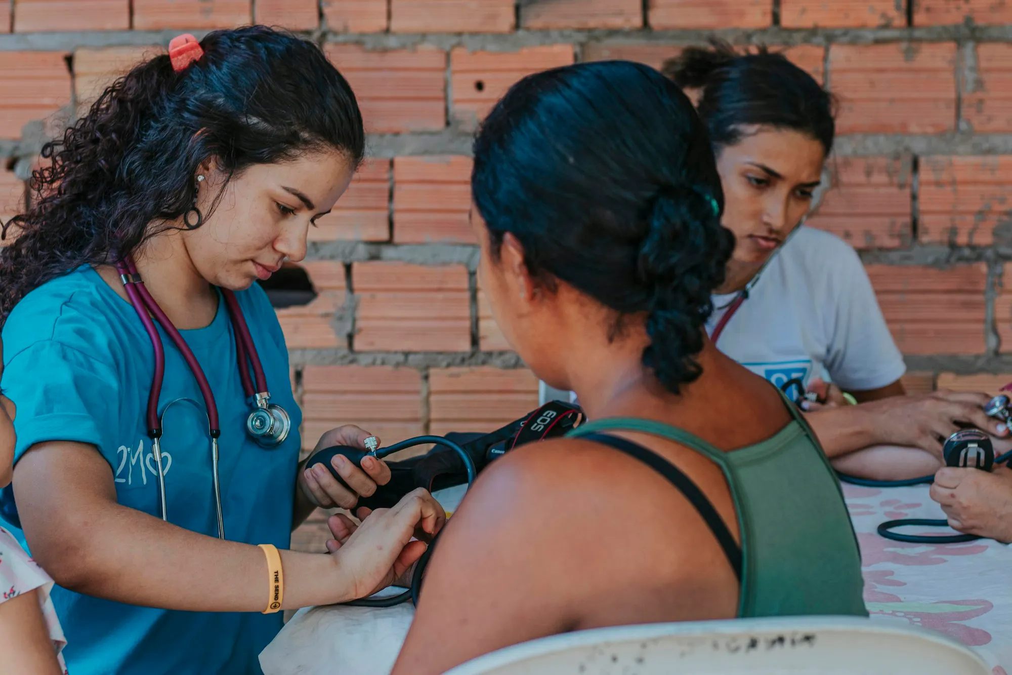 Profesional de salud tomando la presión a una mujer durante una brigada