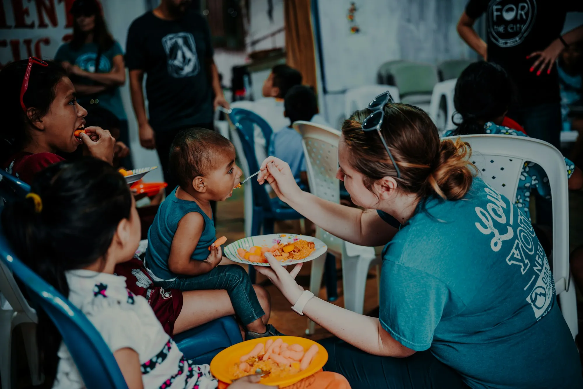 Voluntaria compartiendo un almuerzo con niños durante una jornada comunitaria