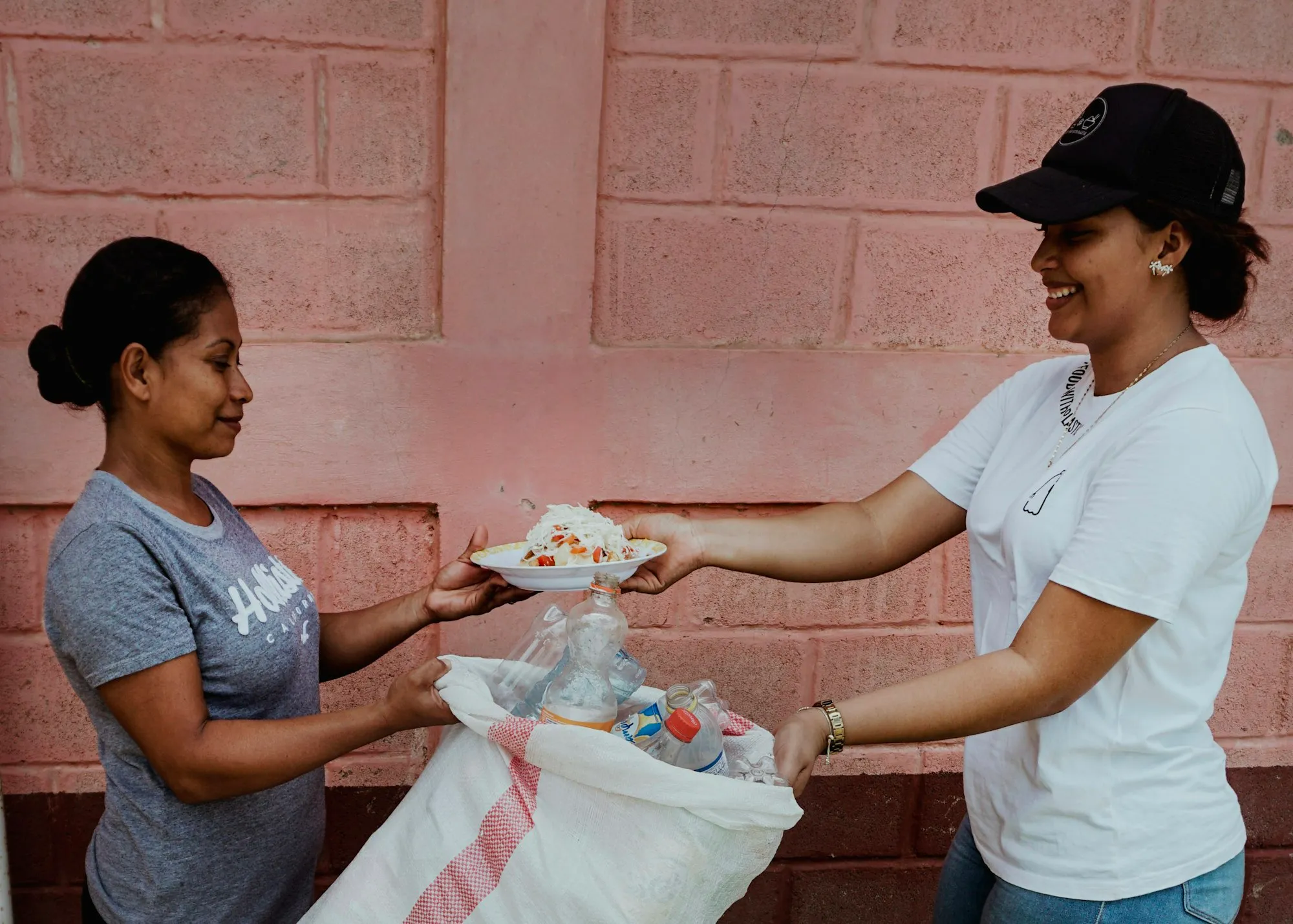 Voluntaria entregando un plato de comida a una vecina