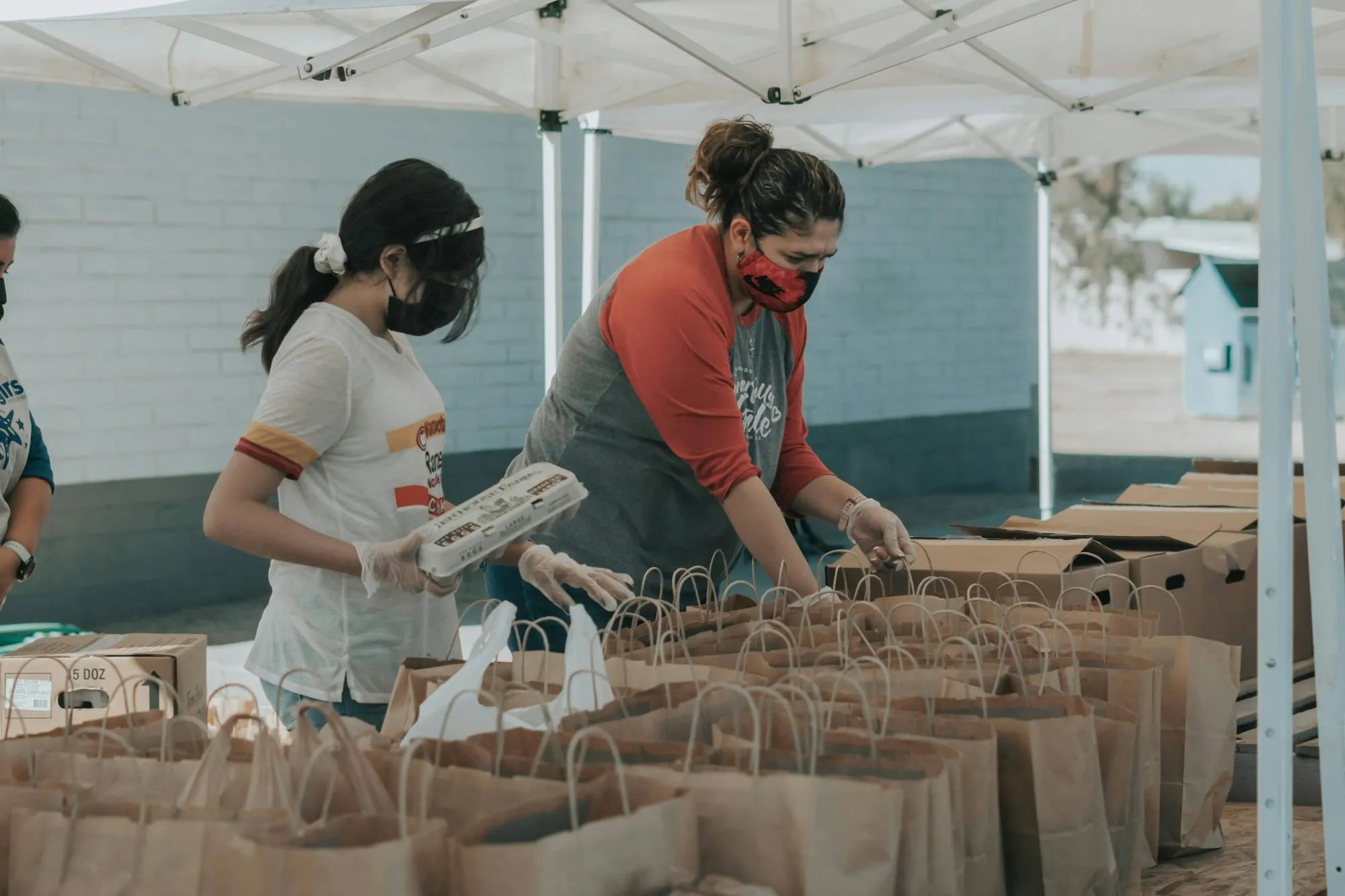 Voluntarias empacando mercados bajo una carpa